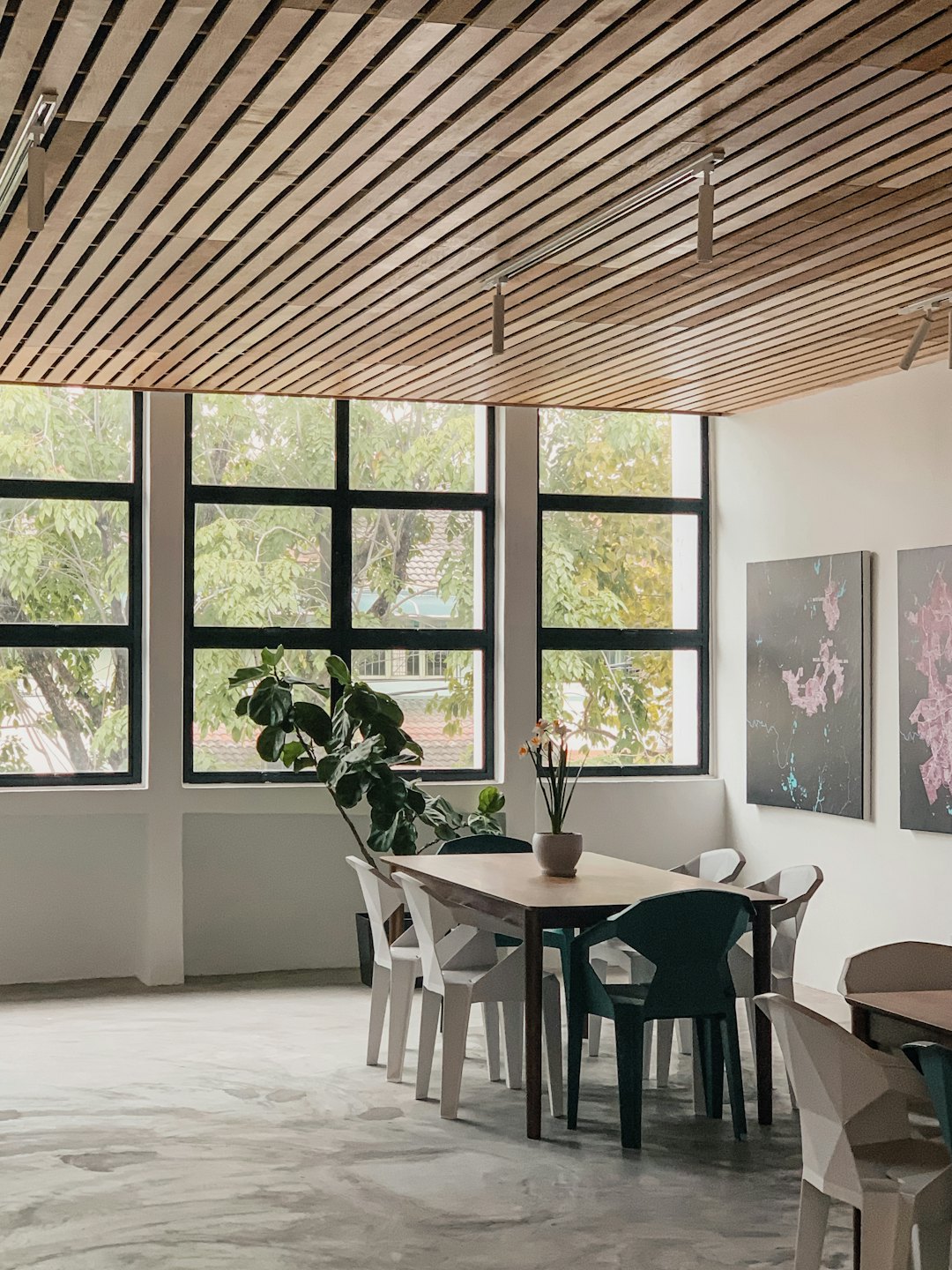 Modern meeting room with wooden ceiling and large windows.